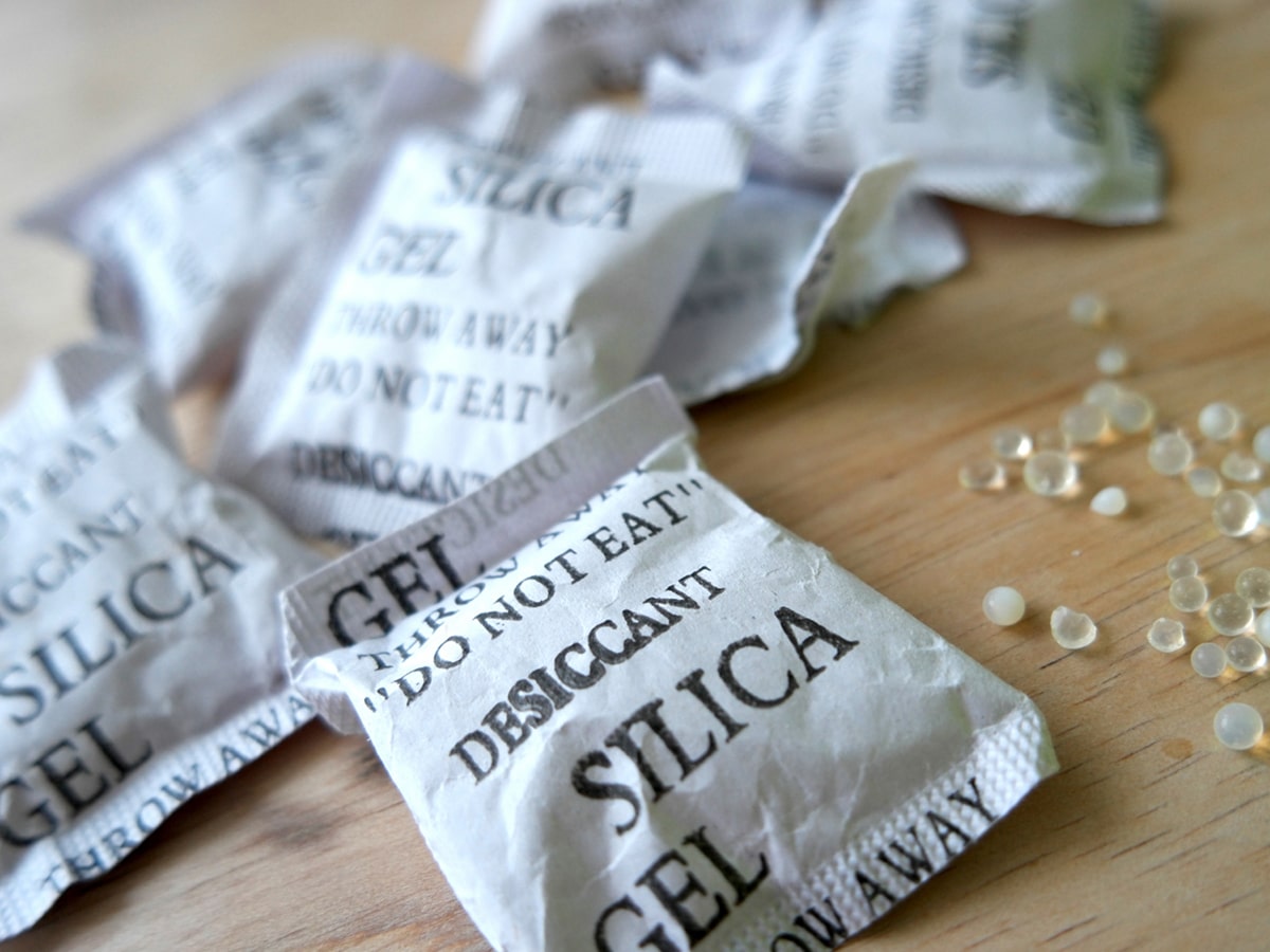 Silica gel packets on a wooden surface.
