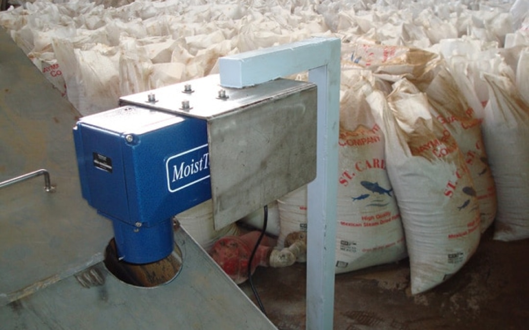 MoistTech moisture measurement device installed on industrial equipment near bagged bulk material