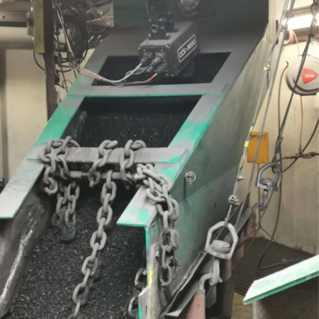Industrial coal conveyor being monitored by a moisture sensor mounted overhead