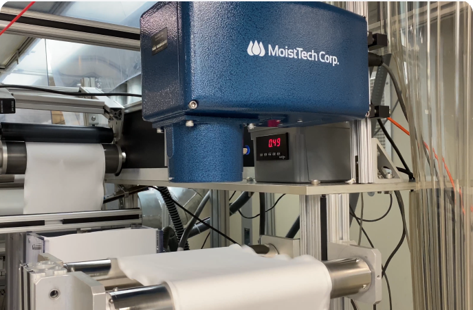 A MoistTech sensor reading moisture on a white sheet of unknown substance