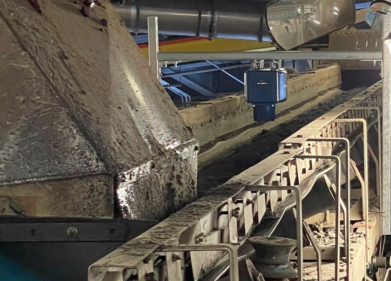 MoistTech moisture sensor installed above a conveyor carrying processed biosolids for real-time moisture measurement.
