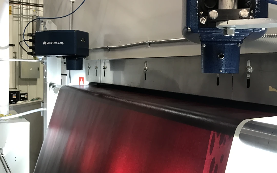 In-line moisture measurement sensor monitoring material on a manufacturing production line.