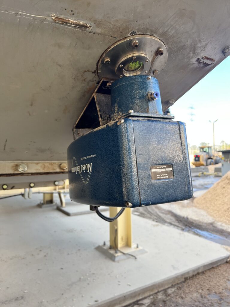 MoistTech online moisture sensor installed beneath wood pellet process equipment for real-time moisture measurement.