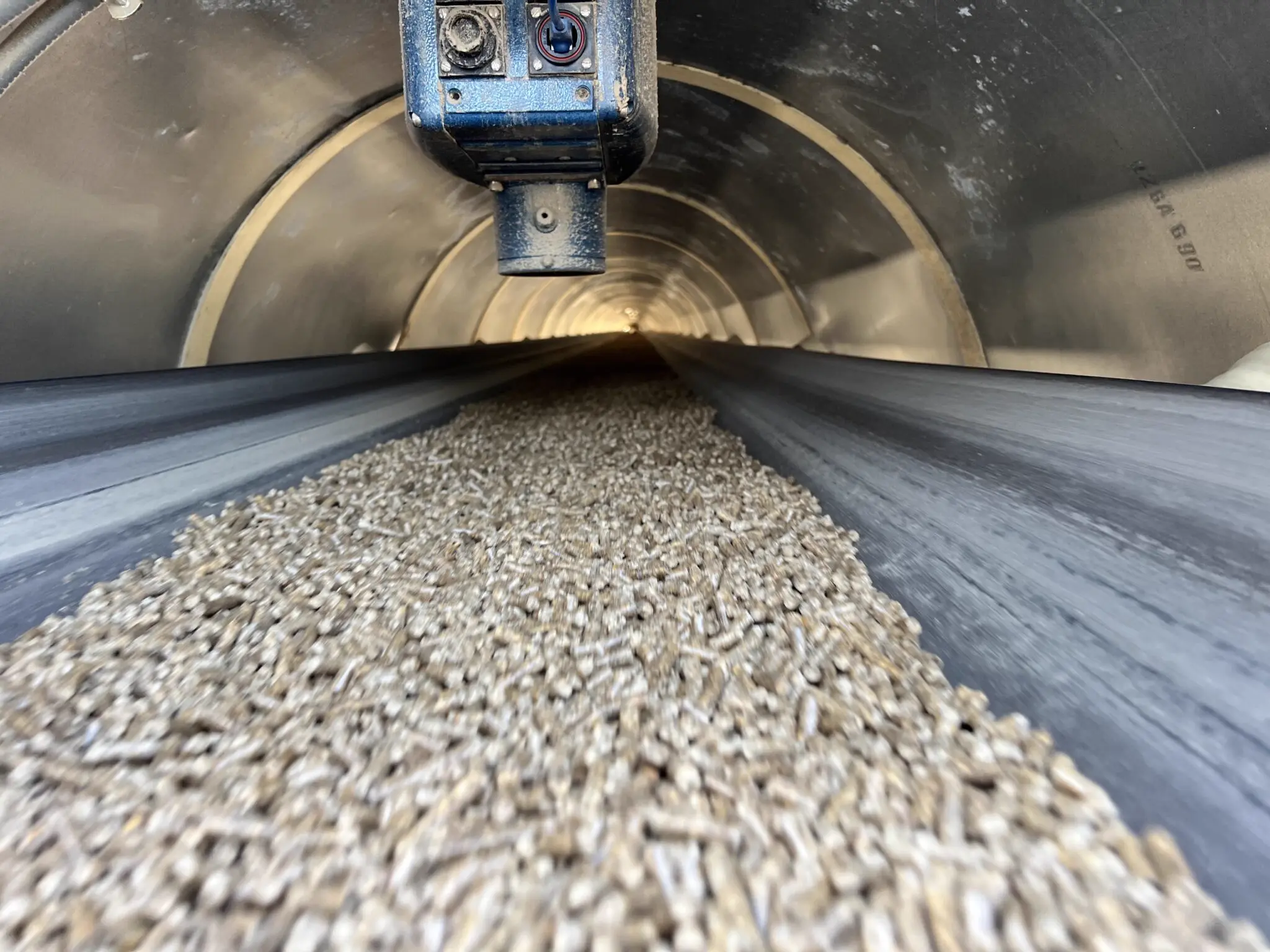 MoistTech IR3000 moisture sensor monitoring wood pellets on a conveyor inside a dryer.