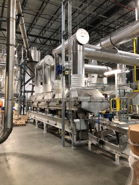 Industrial plastics processing line with stainless steel equipment and overhead ductwork