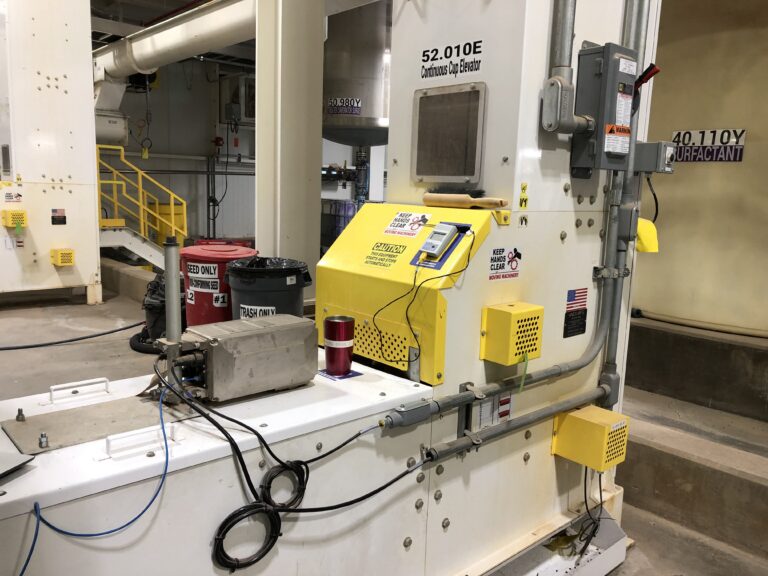 MoistTech near-infrared moisture sensor installed on industrial cottonseed processing equipment.